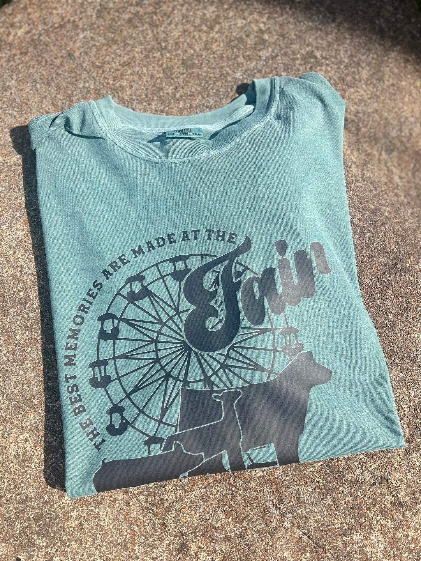 Folded light blue t-shirt with black graphic design on a textured surface