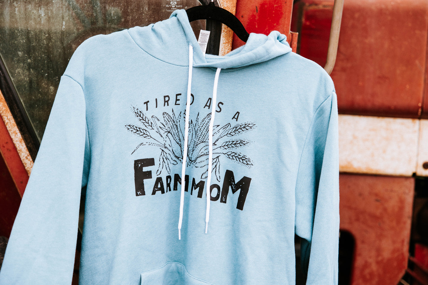 Close up of blue sweatshirt hanging on a red tractor