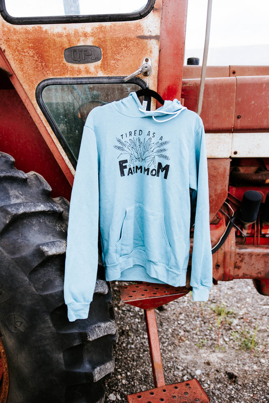 Blue hooded sweatshirt hanging on a red tractor