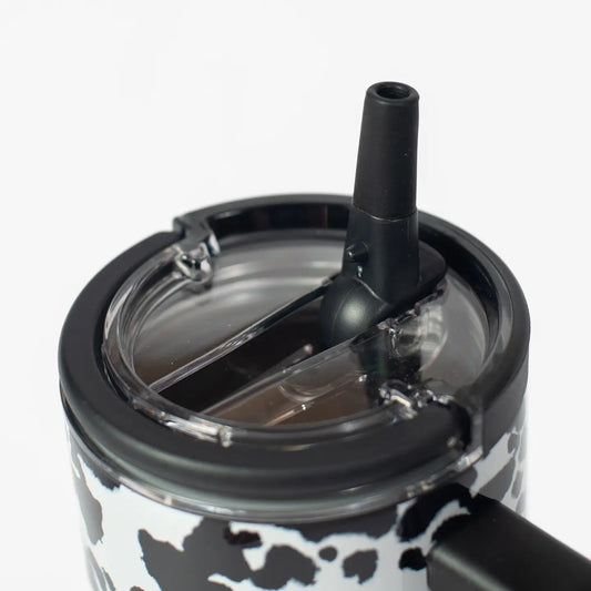 Close-up of a black lid with a straw on a clear cup against a white background