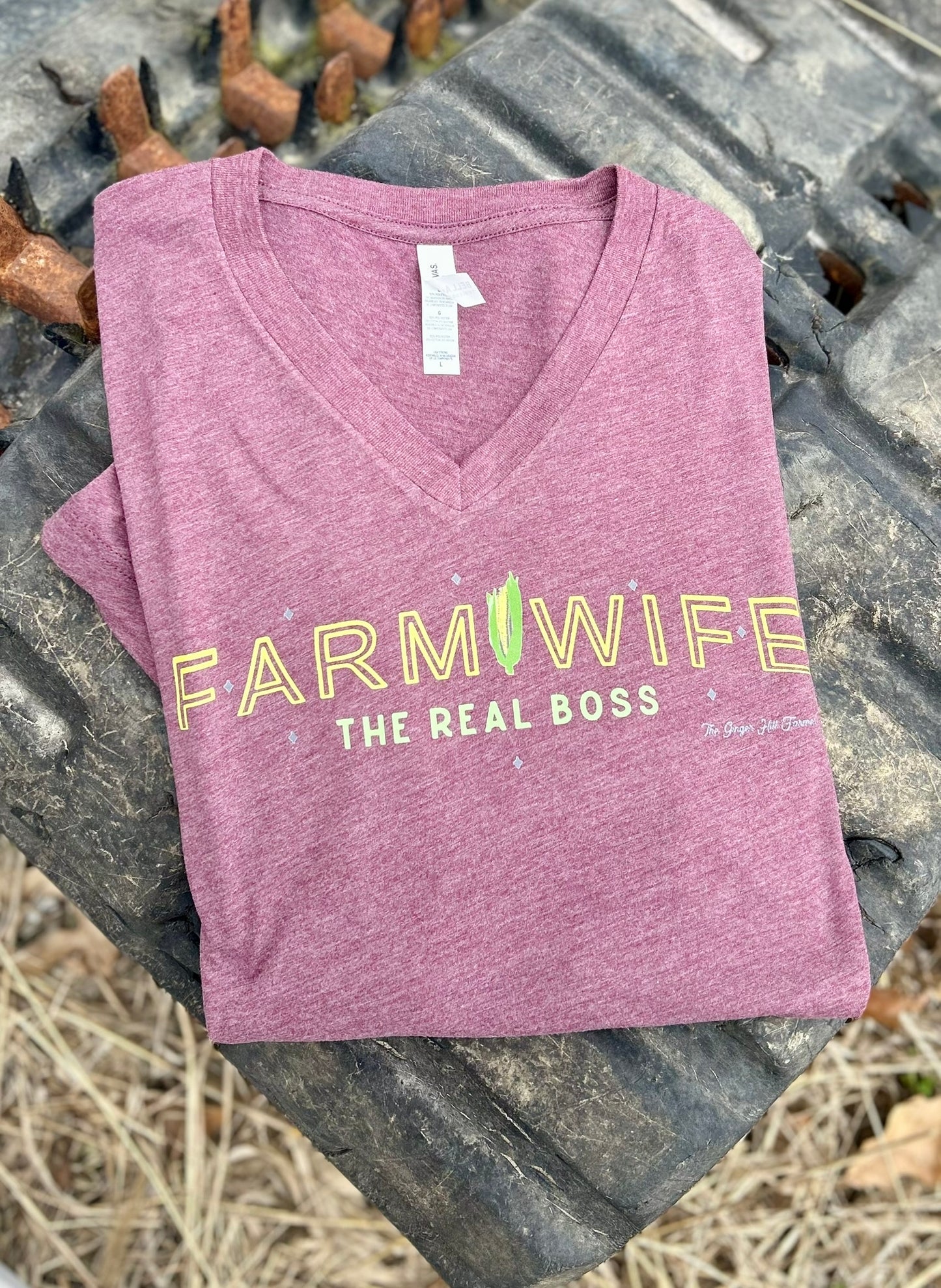 Purple t-shirt with 'Farmwife, The Real Boss' text on a rustic background