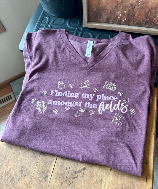 Purple t-shirt with white text and graphics on a wooden surface