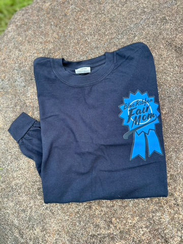 Folded black-shirt with a blue ribbon graphic and text on a concrete surface