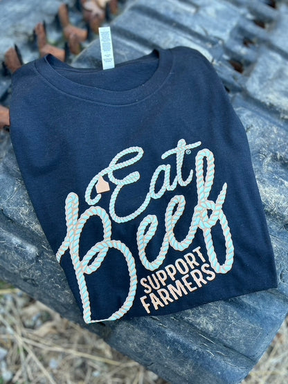 black t-shirt with 'Eat Beef Support Farmers' text on a stone surface