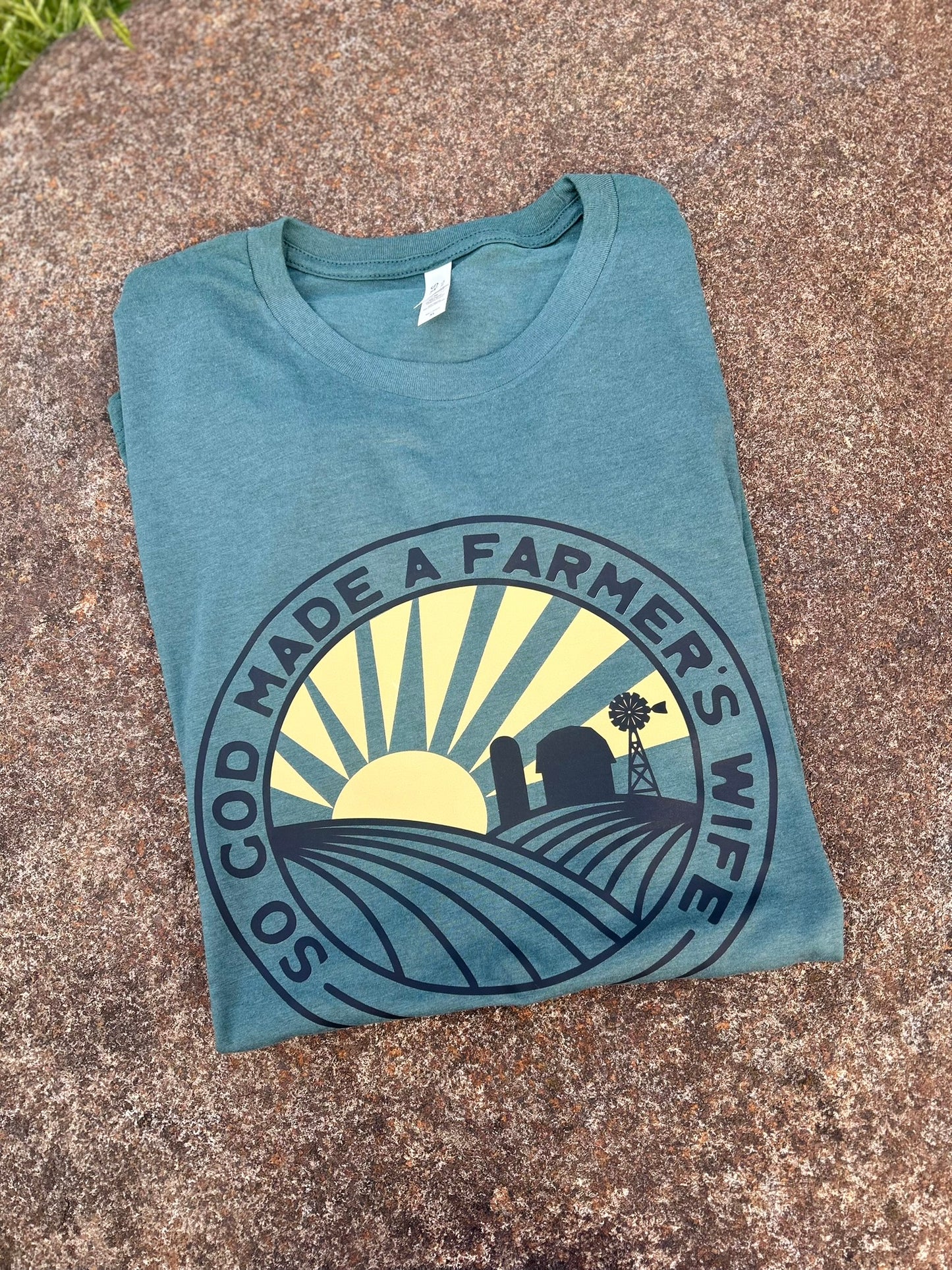 Folded blue t-shirt with a graphic design on a textured surface
