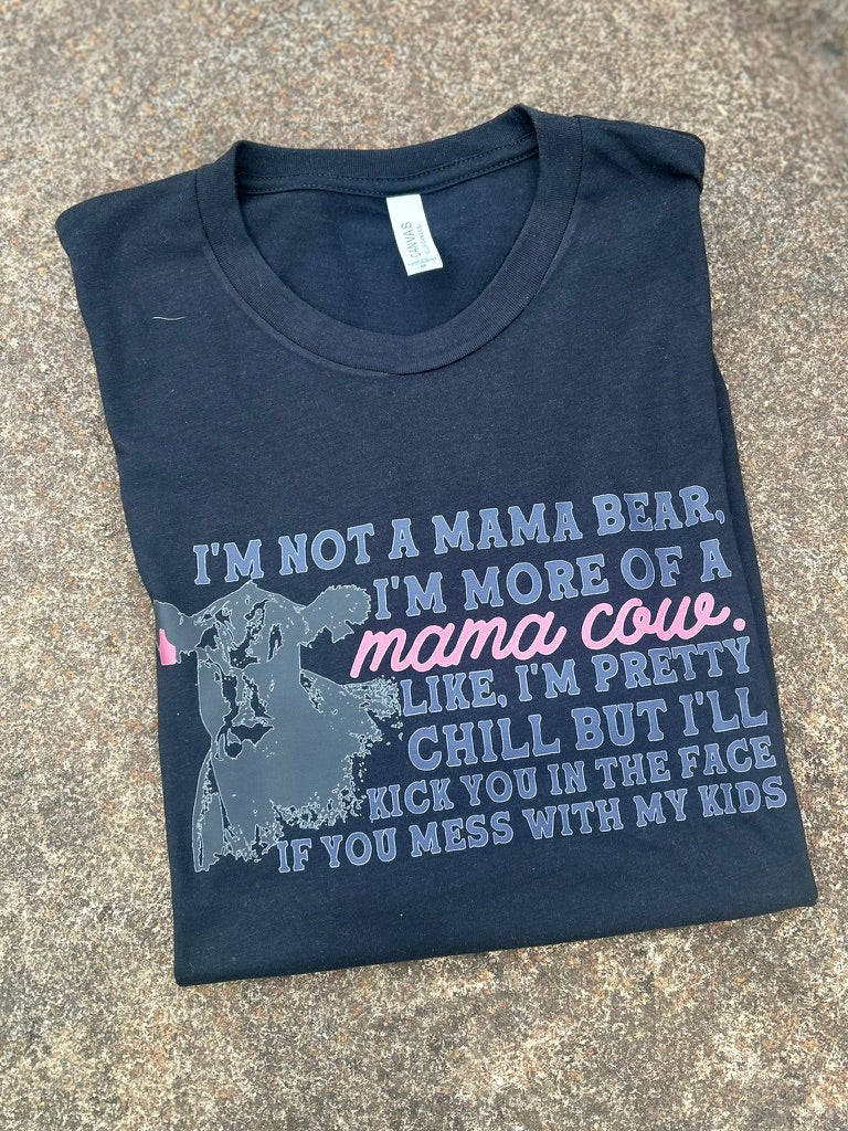 Folded black t-shirt with humorous text design on a concrete surface