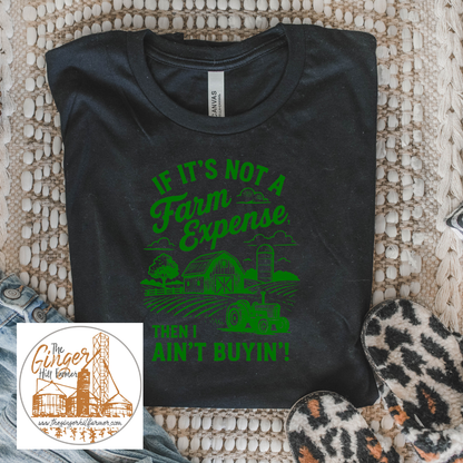 Black t-shirt with green text and graphics on a textured surface, featuring a small inset of a logo.