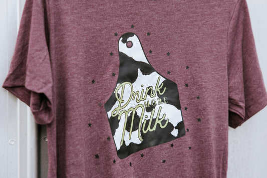 Close up of cattle tag graphic on a maroon tee