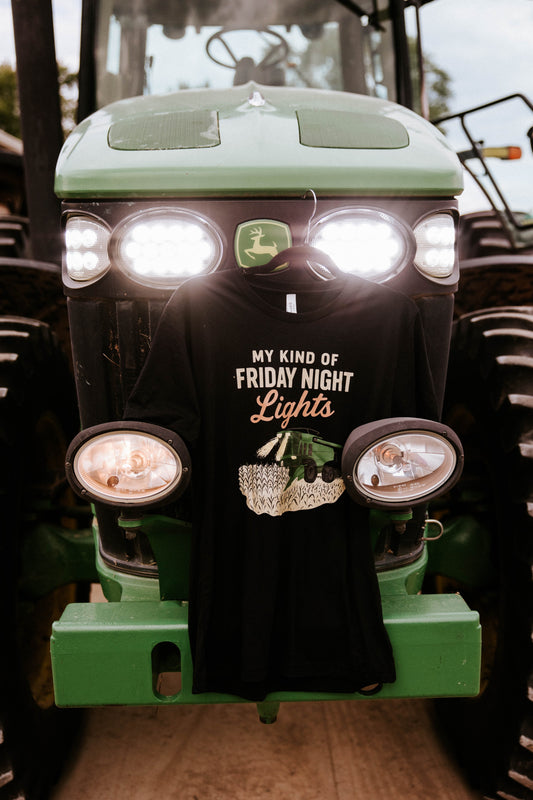 Black T-shirt hanging on the front of a green tractor