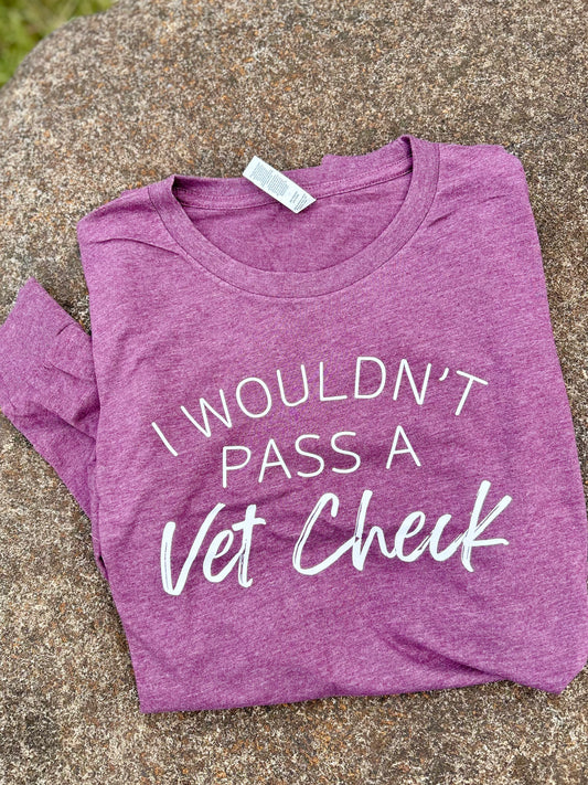 maroon t-shirt with 'I Wouldn't Pass a Vet Check' text on a concrete surface