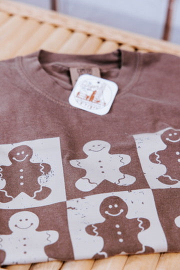 Brown shirt with gingerbread man pattern on a woven surface