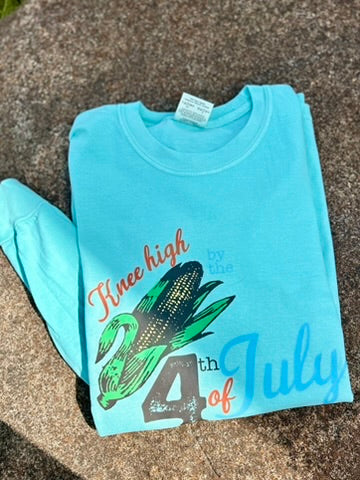 Light blue t-shirt with corn graphic and text on a textured surface