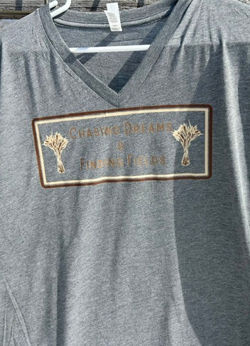 Gray t-shirt with a gold patch on a hanger