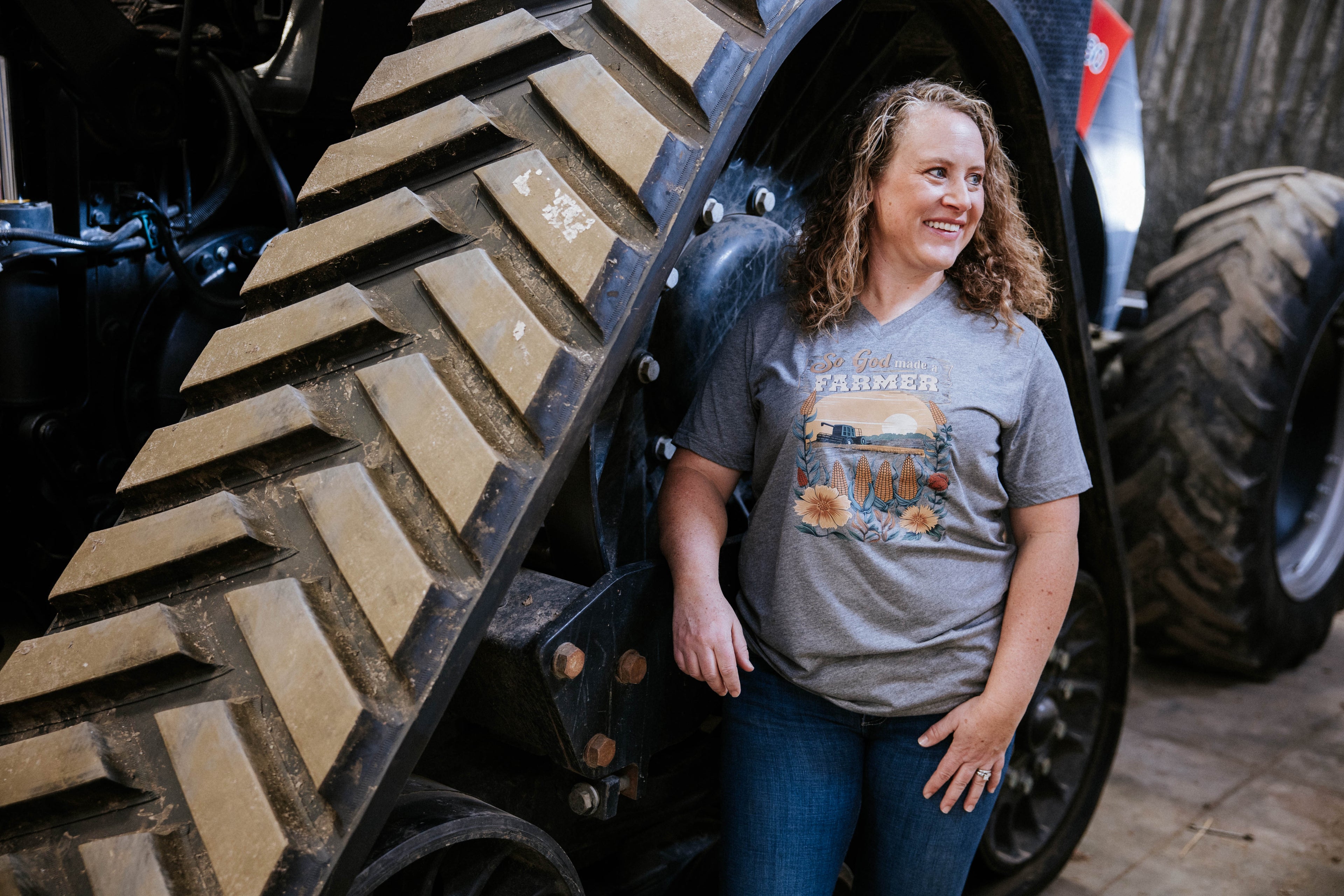 Woman standing next to a large vehicle tire with a graphic t-shirt.