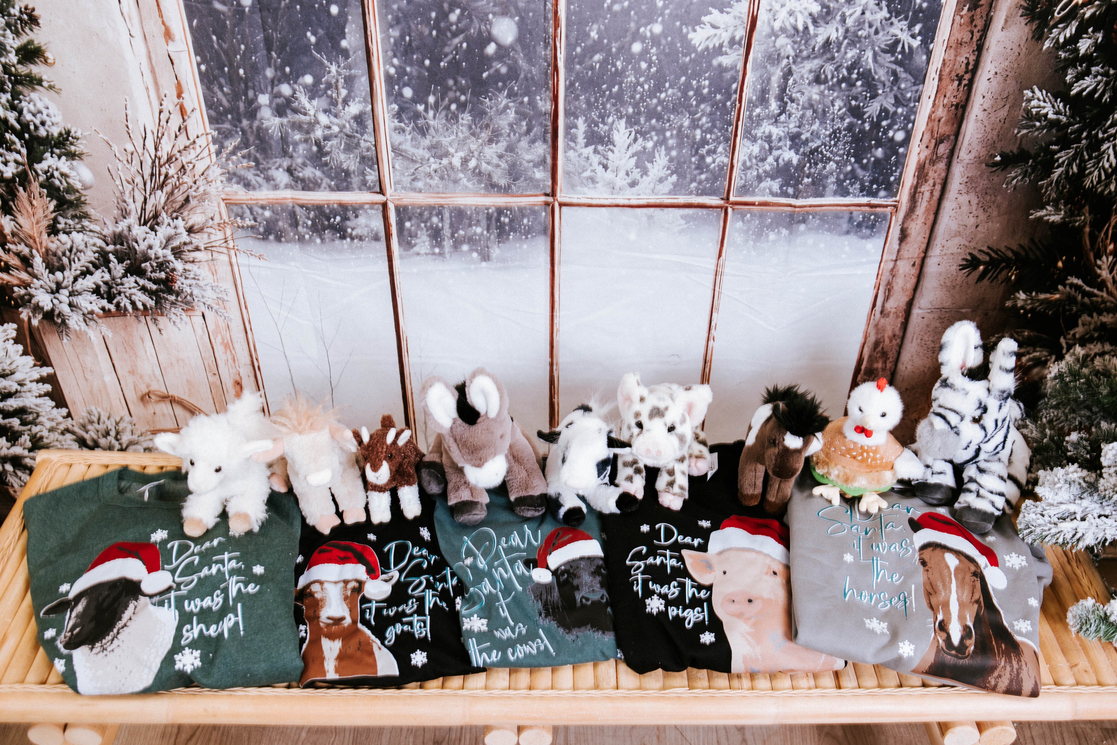 Christmas shirts laying on a bench with stuffed animals