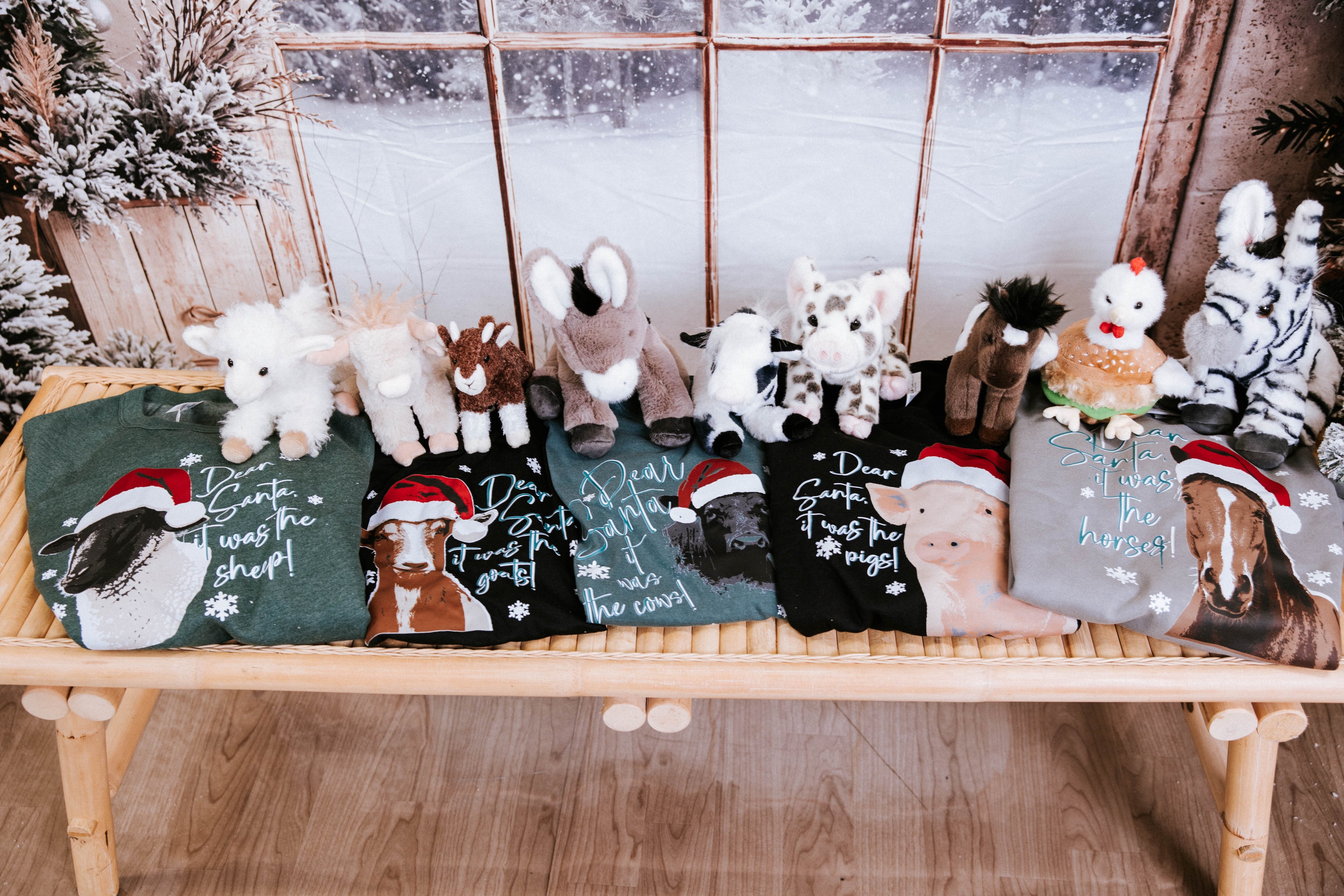 Christmas tees and stuffed animals on a wooden bench 