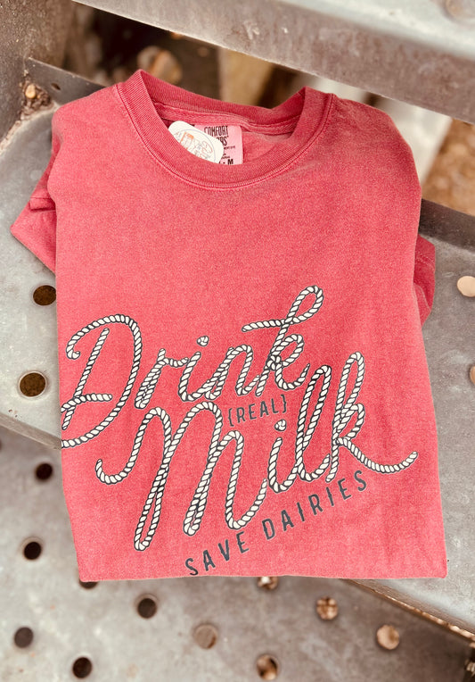 Red t-shirt with 'Drink Real Milk, Save Dailies' text on a metal surface