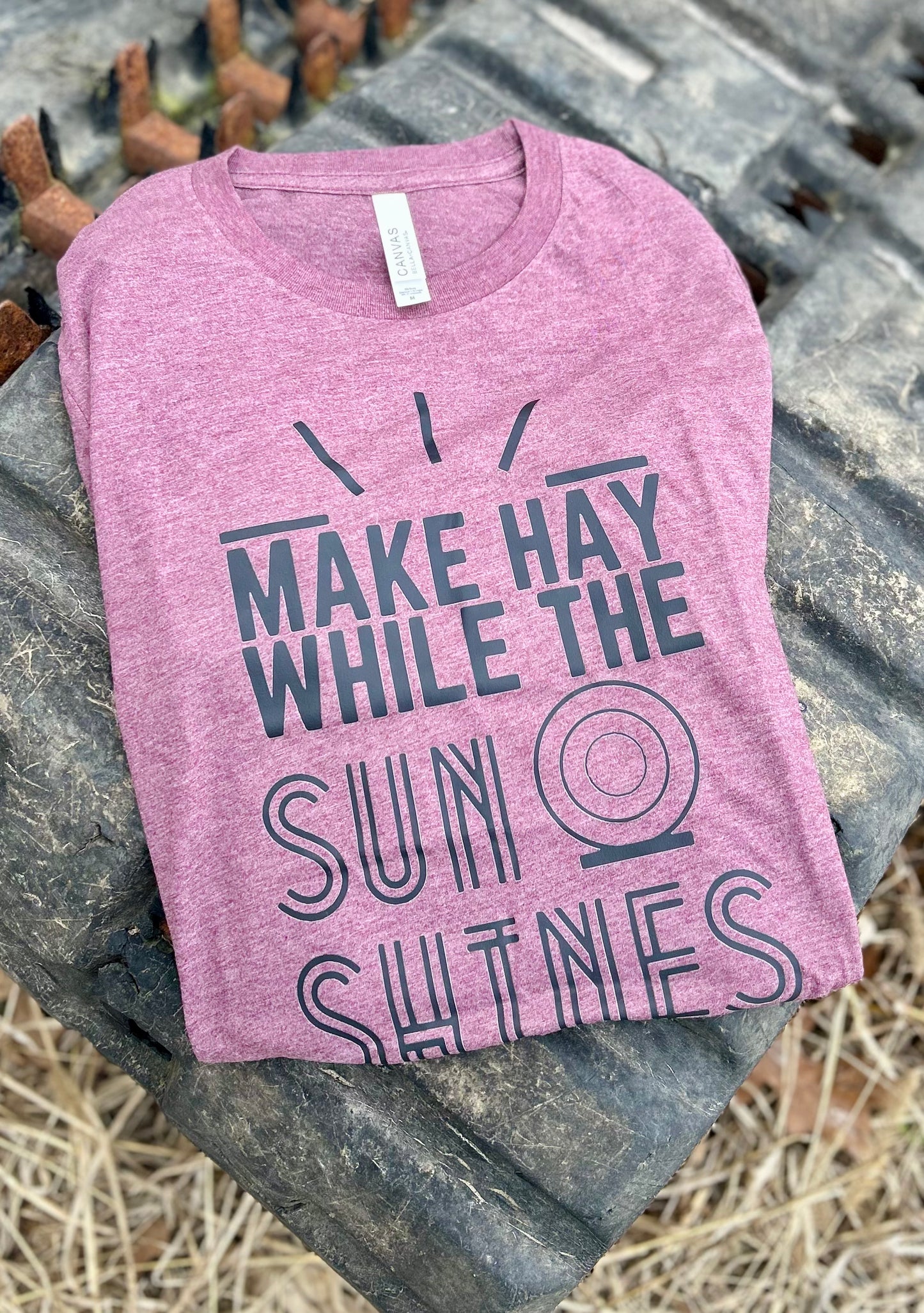 maroon tshirt with black graphic on a tractor tire