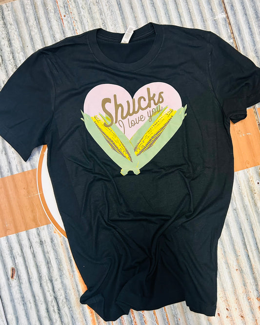 Black t-shirt with a heart-shaped graphic and text on a corrugated metal surface