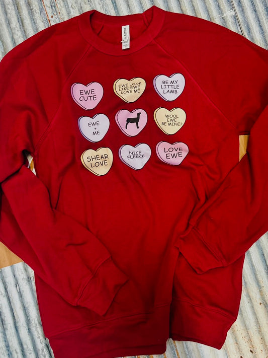Red sweatshirt with heart-shaped patches on a textured surface