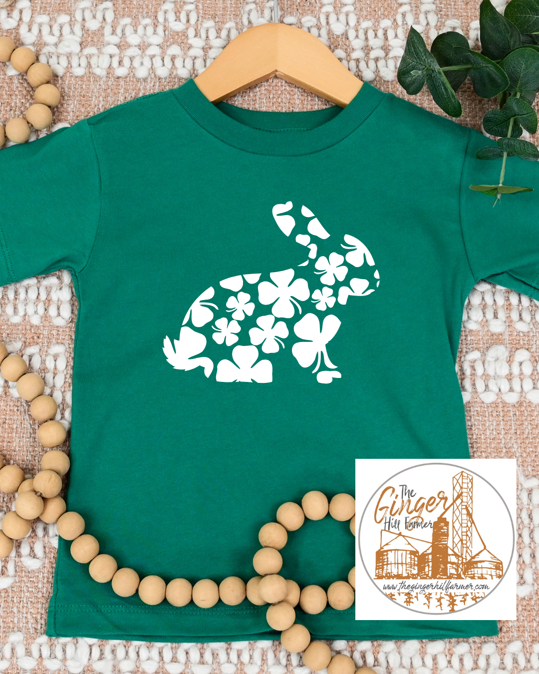 green tee with a rabbit made of clovers on a textured background