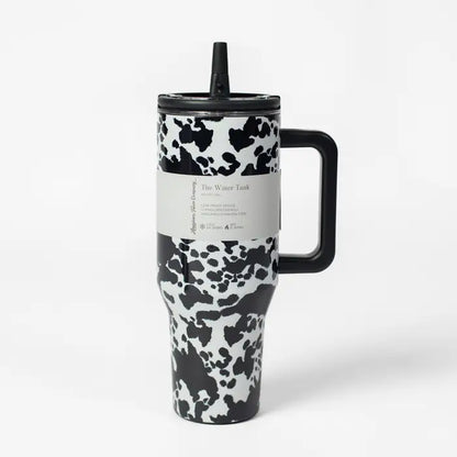 Travel mug with cow print design on a white background