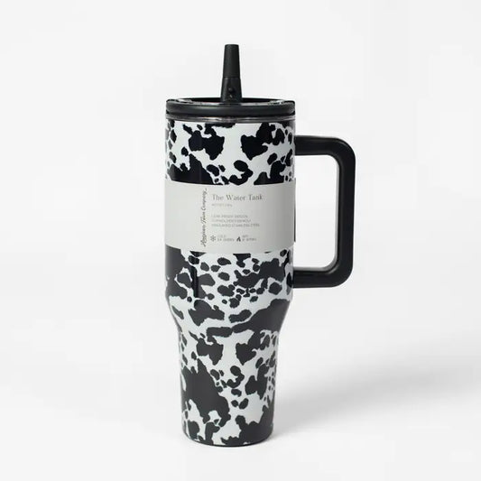 Travel mug with cow print design on a white background