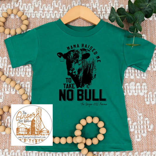 Green t-shirt with a cow graphic and text on a textured surface with beads and leaves.