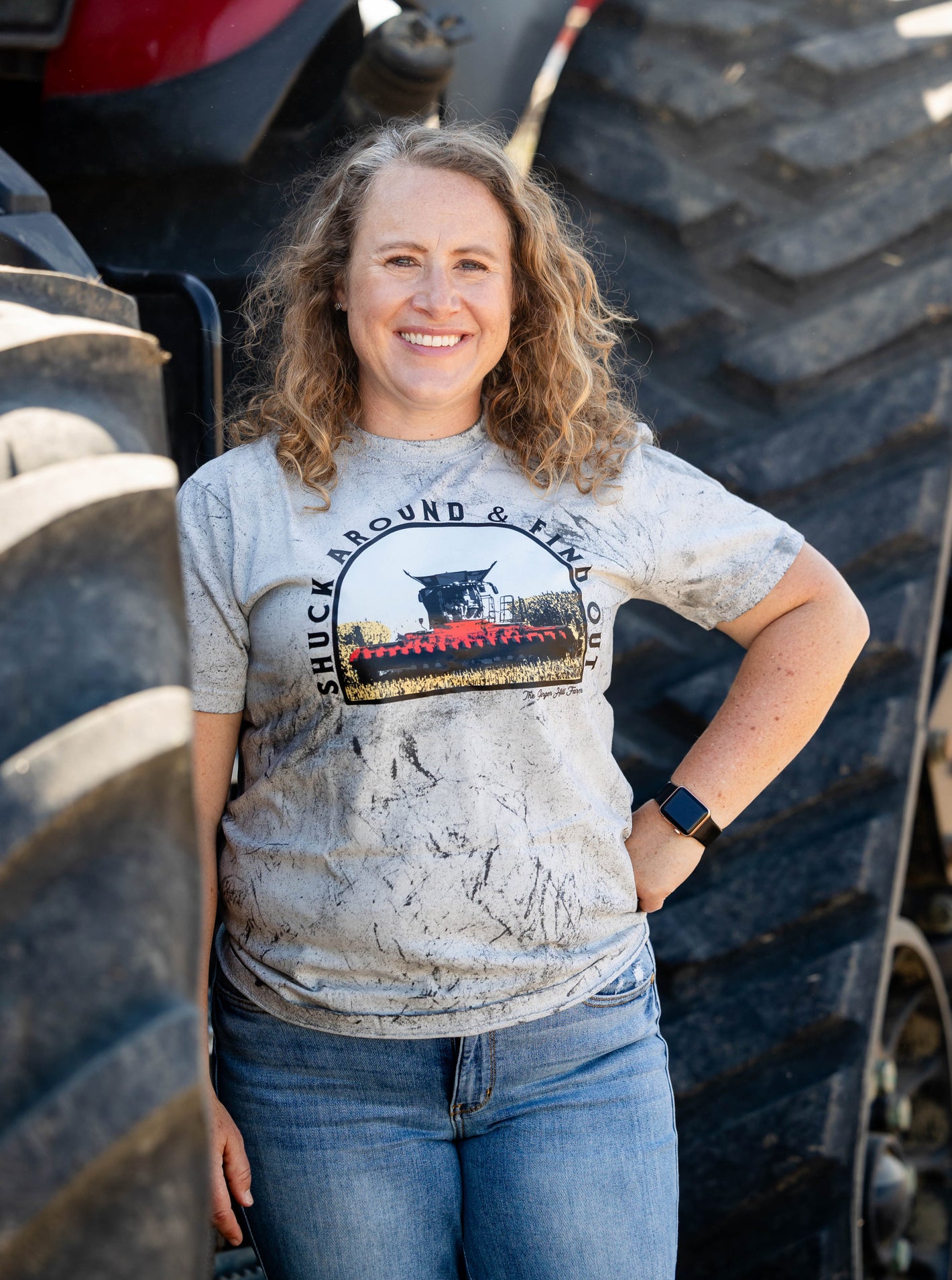 model wearing tee in front of tractor